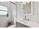 Modern bathroom featuring a gray vanity, white tiling, and natural light at 2008 Harvard Ave, Dunedin, FL 34698