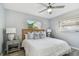 Bright bedroom featuring a ceiling fan, wood-look flooring, and natural light from two windows at 2008 Harvard Ave, Dunedin, FL 34698