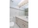 Bright bathroom features tiled walls and floors, and a vanity with ample storage at 2101 Sunset Point Rd # 1003, Clearwater, FL 33765