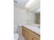 Bright bathroom features tiled walls and floors, and a vanity with ample storage at 2101 Sunset Point Rd # 1003, Clearwater, FL 33765