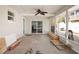 This patio includes a ceiling fan, a sliding glass door and a white wall with a blue trim window at 2460 Baywood E Dr, Dunedin, FL 34698