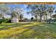 Spacious backyard with lush green grass, large trees, and a shed for storage at 270 41St Ne Ave, St Petersburg, FL 33703