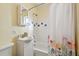 Bathroom with shower/tub combination featuring patterned shower curtain, tiled walls, and vanity sink at 270 41St Ne Ave, St Petersburg, FL 33703