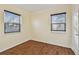 Bright bedroom featuring wood-look flooring, and two windows with blinds at 270 41St Ne Ave, St Petersburg, FL 33703