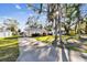 Single-story home with a covered entrance, long driveway, and mature trees offering shade and privacy at 270 41St Ne Ave, St Petersburg, FL 33703