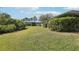 A view of the backyard with a well-manicured lawn and some trees around the house at 2725 Countryside Blvd # 103, Clearwater, FL 33761