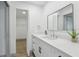 Bathroom vanity features shaker cabinets, quartz countertop, modern faucet, and framed mirror with closet view at 2725 Countryside Blvd # 103, Clearwater, FL 33761