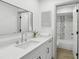 Bathroom vanity features shaker cabinets, quartz countertop, modern faucet, and framed mirror with shower view at 2725 Countryside Blvd # 103, Clearwater, FL 33761