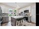 Modern kitchen featuring gray and white cabinets, an island with a white countertop, pendant lighting, and stainless steel appliances at 3017 Sanchez St # 1/2, Tampa, FL 33605