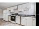 Kitchen featuring tile floors, white cabinets, black appliances, and stainless steel sink at 3017 Sanchez St # 1/2, Tampa, FL 33605