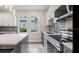 Modern kitchen featuring gray and white cabinets, an island with a white countertop, pendant lighting, and stainless steel appliances at 3017 Sanchez St # 1/2, Tampa, FL 33605