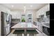 Modern kitchen featuring gray and white cabinets, an island with a white countertop, pendant lighting, and stainless steel appliances at 3017 Sanchez St # 1/2, Tampa, FL 33605