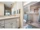 Well-lit bathroom featuring a vanity with drawers, mirror, and shower with sliding door at 308 Los Prados Dr # 308, Safety Harbor, FL 34695