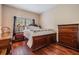 Bedroom with wood floors, side table, and a window with blinds providing plenty of light at 308 Los Prados Dr # 308, Safety Harbor, FL 34695