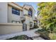 Inviting two-story townhome with a well-manicured walkway leading to the entrance and lush tropical landscaping at 308 Los Prados Dr # 308, Safety Harbor, FL 34695