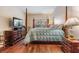 Main bedroom featuring a four-poster bed, hardwood floors, and plenty of natural light at 308 Los Prados Dr # 308, Safety Harbor, FL 34695