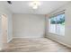 This bedroom has modern gray walls, light wood flooring, and natural light from a large picture window at 31031 Whitlock Dr, Wesley Chapel, FL 33543