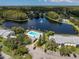 Scenic aerial view of the community lake, fountain, swimming pool, and surrounding landscaping at 3161 Lake Pine S Way # F1, Tarpon Springs, FL 34688