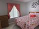 Bright bedroom with a large window, coral curtains, and a bed with seashell-themed bedding at 3161 Lake Pine S Way # F1, Tarpon Springs, FL 34688