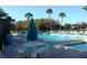 Relaxing community pool area with lounge chairs, tables with umbrellas, and palm trees at 3161 Lake Pine S Way # F1, Tarpon Springs, FL 34688