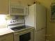 Kitchen with white appliances including a microwave, oven and refrigerator at 3161 Lake Pine S Way # F1, Tarpon Springs, FL 34688