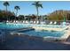 Outdoor swimming pool and hot tub surrounded by lounge chairs and umbrellas at 3161 Lake Pine S Way # F1, Tarpon Springs, FL 34688