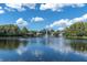 Scenic waterfront with a fountain on a serene lake surrounded by lush greenery and blue skies at 3161 Lake Pine S Way # F1, Tarpon Springs, FL 34688