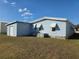 Exterior view with awnings, shed, and well-maintained siding at 36830 Kimela Ave, Zephyrhills, FL 33542