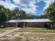 Charming single-story brick building featuring a metal roof and well-maintained landscaping at 36830 Kimela Ave, Zephyrhills, FL 33542