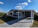 Inviting exterior view showcasing the home's covered parking, manicured lawn and front entry at 36830 Kimela Ave, Zephyrhills, FL 33542