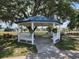 Charming white gazebo offers a serene gathering spot amidst a well-maintained community landscape at 36830 Kimela Ave, Zephyrhills, FL 33542