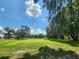 Expansive golf course with lush green grass and mature trees under a blue sky at 36830 Kimela Ave, Zephyrhills, FL 33542