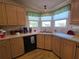 Charming kitchen with wood cabinetry, laminate countertops, and a stainless-steel sink under a bright window at 36830 Kimela Ave, Zephyrhills, FL 33542