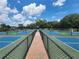 View from the brick pathway of outdoor pickleball courts, showcasing fencing and playing surfaces at 36830 Kimela Ave, Zephyrhills, FL 33542