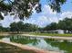 Enjoy the scenic pond, with lush trees reflecting on the tranquil water at 36830 Kimela Ave, Zephyrhills, FL 33542