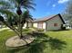 Charming one-story home featuring lush landscaping, a well-manicured lawn, and red shutters at 3917 103Rd N Ave, Clearwater, FL 33762