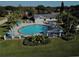 An aerial view captures the community pool, surrounded by lounge chairs and lush greenery at 3917 103Rd N Ave, Clearwater, FL 33762