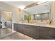 Bathroom with dual sinks, modern fixtures, and a glass-enclosed shower at 450 Knights Run Ave # 1005, Tampa, FL 33602