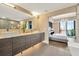 Modern bathroom with dual sinks, wood cabinets, and a view of the main bedroom at 450 Knights Run Ave # 1005, Tampa, FL 33602