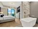 Luxury bedroom with a crystal chandelier and a marble bathtub, complemented by city views at 450 Knights Run Ave # 1005, Tampa, FL 33602