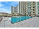 Rooftop pool surrounded by high-rise buildings with poolside lounge chairs and manicured landscaping at 450 Knights Run Ave # 1005, Tampa, FL 33602