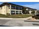 Exterior view of a well-maintained condominium building with manicured lawns, sidewalks, and mature landscaping at 4715 Jasper Dr # 208, New Port Richey, FL 34652