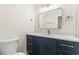 Modern bathroom with a blue vanity, gold fixtures, and a sleek mirror at 4908 Stolls Ave, Tampa, FL 33615