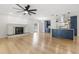 Bright open living room featuring a fireplace, ceiling fan, and a modern kitchen at 4908 Stolls Ave, Tampa, FL 33615