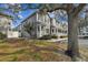 Street view of townhomes featuring gray siding, white trim, manicured lawns and mature trees at 4927 Elizabeth Anne Cir, Tampa, FL 33616