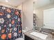 Bathroom with sports themed shower curtain, granite countertop, and a modern sink at 5446 Blue Azure Dr, Wimauma, FL 33598