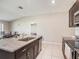 Open kitchen with an island, stainless steel appliances, granite counters, and tile flooring at 5446 Blue Azure Dr, Wimauma, FL 33598