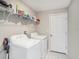 Bright laundry room with white washer and dryer, plus a convenient wire shelf for storage at 5446 Blue Azure Dr, Wimauma, FL 33598