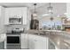 Kitchen featuring stainless steel appliances and granite countertops with modern light fixtures at 6029 Bayway Ct, New Port Richey, FL 34652