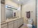 Well-lit bathroom with vanity, granite countertops, toilet, and a modern glass block shower at 635 13Th Ne Ave, St Petersburg, FL 33701